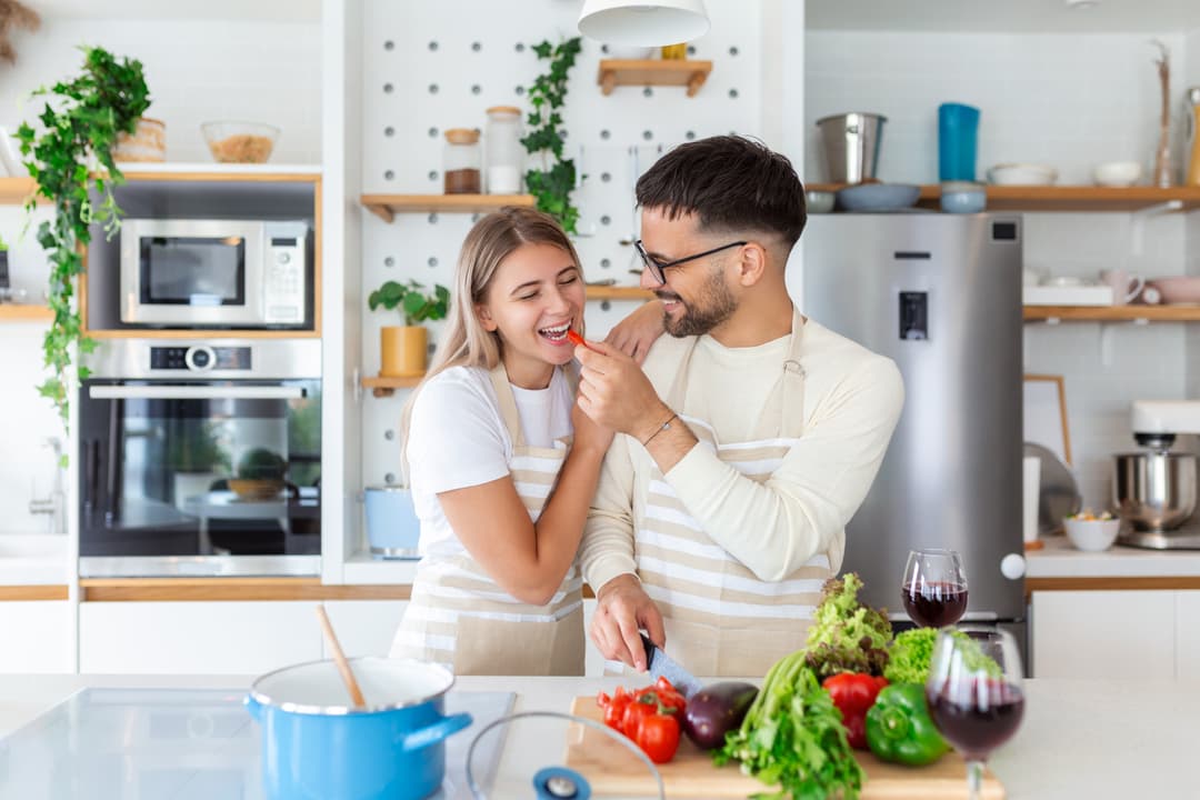 Cheerful couple cooking together in the kitchen